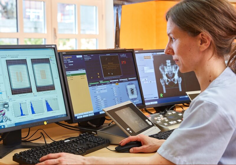 Medical physicist in fornt of a computer screen showing the Delta4 software